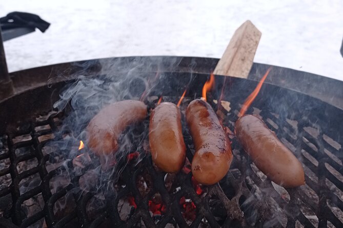 Ice fishing experience with Backpacker Helsinki Tour - The fire, sausage, glögi, and piparri finish the day