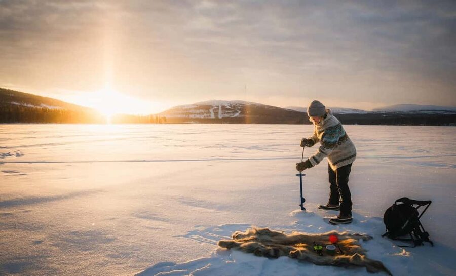 Pyhä: Ice Fishing Experience at Frozen Lake - Drilling through the frozen lake